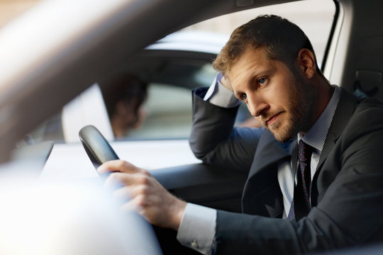 Unhappy Businessman Stuck In Traffic Inside Car