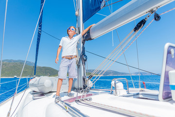 Little boy on board of sailing yacht on summer cruise. Travel adventure, yachting with child on family vacation.