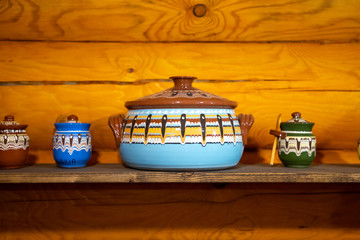 Old fashioned kitchen utensils in Russian folk style on wooden wall background