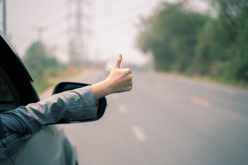 Freedom independence liberty concept, women hand giving a thumbs up sign throw the window of a car...
