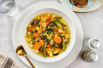 Spring vegetable soup on light background