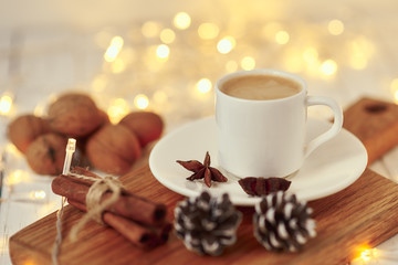 Obraz na płótnie Canvas Cozy autumn or winter concept. Cup of coffee with a garland lights and decoration/