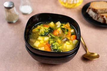 Spring vegetable soup in a black bowl
