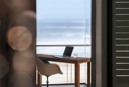 Laptop On Desk In Modern Home Office Overlooking Ocean