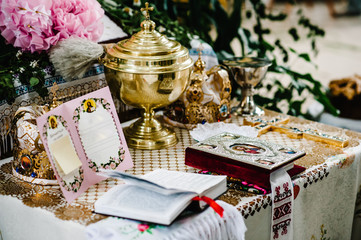 Wedding crowns in church ready for marriage ceremony. close up. Bible, crown, bowl, Certificate of the glans in the church on table. Place for text.