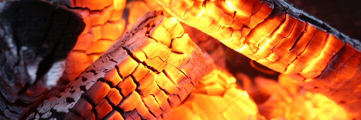 Close-up of burning log in bonfire. Large orange flame from fire with woods. Light and ash from...