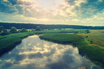 Aerial view of countryside and brook in evening at sunset light. Beautiful nature landscape