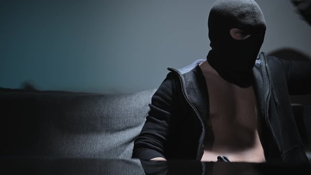 Caucasian Mafia Soldier or Gang Member with Hand Gun Wearing Black Mask. 