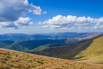 Colorful mountain landscape in the summer mountains. Large hills with blue sky.