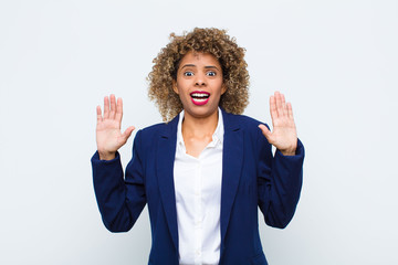 young woman african american feeling stupefied and scared, fearing something frightening, with...