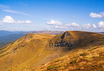 Colorful mountain landscape in the summer mountains. Large hills with blue sky.