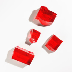 Misshapen pieces of red jelly, isolated on a white background - obrazy, fototapety, plakaty