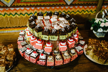 Sweet table. A plates of cakes and muffins with cream with berries. Table with sweets, candy, buffet. Dessert table for a party goodies. Close up. party reception, decorated in restaurant. candy bar