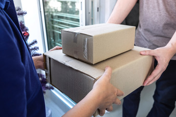 Young Delivery man deliver box parcel package and sending to customer in front of the house and Man receive package, shipping delivery concept
