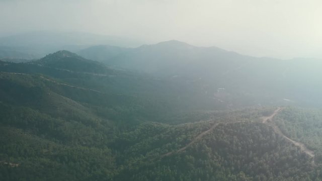 Aerial view of foggy morning in green mountain nature landscape panorama in Cyprus, drone shot