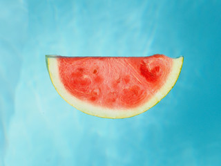 Slice of watermelon in the pool water.