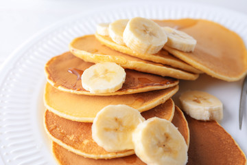 Plate with tasty pancakes and banana on table, closeup