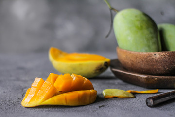 Fototapeta na wymiar Photo of fresh green mango in a bowl. Mango slice with green leaves. Healthy breakfast. Tropical fruit. Summer. Still life photography. Image
