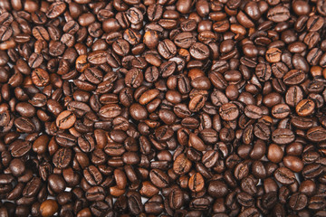 Fototapeta premium Świeże palone ziarna kawy brązowy, widok z góry nasion tekstury jako tło żywności dla projektu.