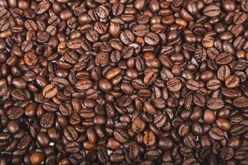 Fresh roasted brown coffee beans, top view of seeds texture as food background for design.