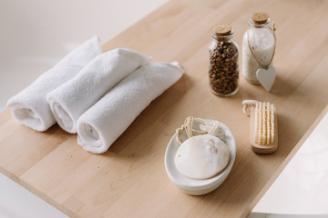 Small and clean white towels on a wooden board. Stylish bathroom details. Spa and relax concept