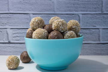 Energy balls of peanut paste and cocoa with oatmeal in a mint-colored ceramic plate