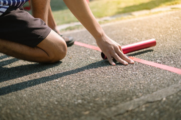 Man Asian athlete ready to start relay race on running track