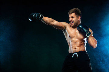 Fitness and boxing concept. Boxer, man fighting or posing in gloves on dark background. Individual...