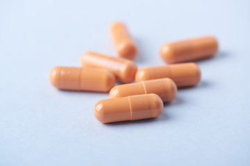 HMB (β-Hydroxy β-methylbutyric acid) capsules. Bodybuilding food supplements on bright paper background. Close up. 