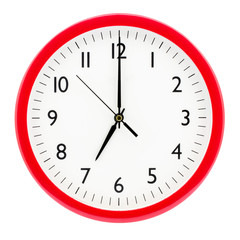 Clock with red round frame on white isolated background shows 7(19) hours 00 minutes_