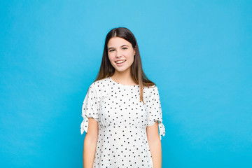young pretty woman with a big, friendly, carefree smile, looking positive, relaxed and happy,...