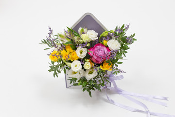 bright fresh composition of fresh flowers (colors: white, pink, purple) (flowers: rose, eustoma, lily, carnation) in a gift box in the form of an envelope on a white background