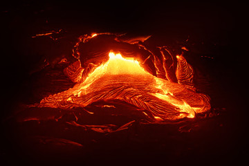 Detailed view of an active lava flow, hot magma emerges from a crack in the earth, the glowing lava...