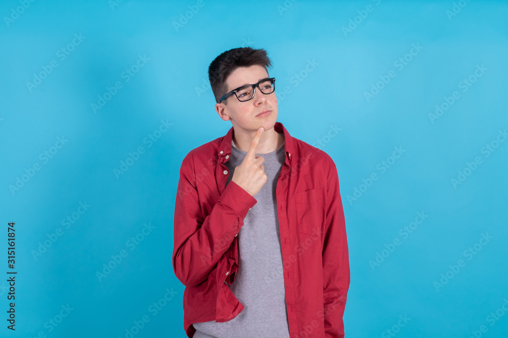 Wall mural young teenage man thinking isolated on color background