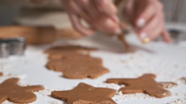 The process of making gingerbread cookies in the form of a Christmas tree, stars, man, hearts from raw dough on the table. Fun, holidays, sweets