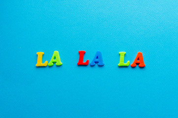 La la la from colored magnetic letters on blue background
