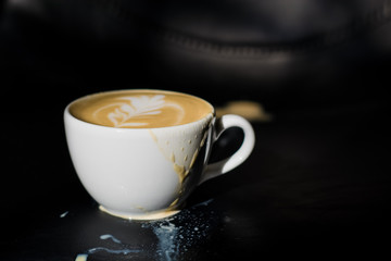 White ceramic a cup of cappuccino with picture spilled, latte art in coffee shop. The morning drink.