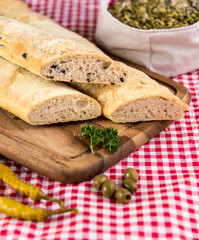 on a white wooden board lies sliced bread and beside it lies a knife