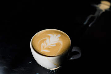 White ceramic a cup of cappuccino with picture spilled, latte art in coffee shop. The morning drink.