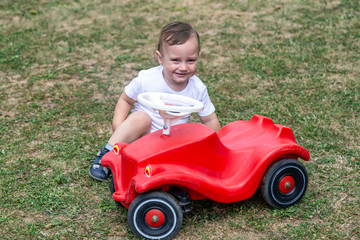 Little boy playing with red color toy car