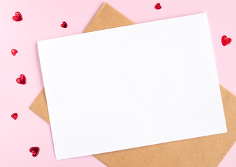 Minimalistic card mockup with envelope, postcard, red hearts on pink background. Flat lay, top view, copy space. Valentines day, birthday concept.