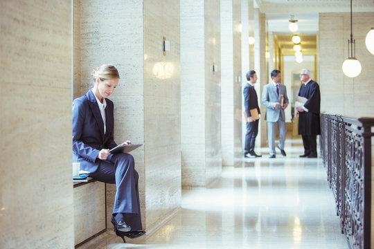 Lawyer Working On Digital Tablet In Courthouse