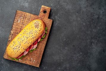 large panini sandwich with sausage and cheese on a stone background with copy space for your text