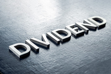 the word dividend laid by volumetric silver metal letters on gloss painted board background with...