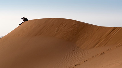 fotógrafo en el borde de una duna del desierto