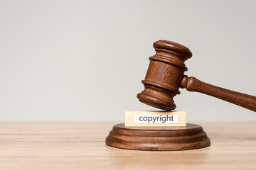 gavel and wooden block with copyright inscription on wooden desk isolated on grey