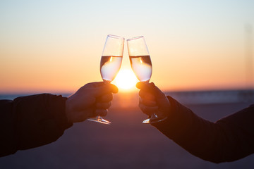 man and woman with glass of wine at sunset