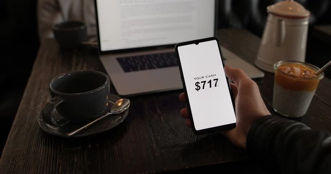 Man make the money with smartphone holding screen with cash counter. Internet marketing concept.