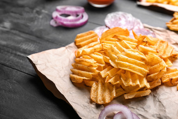 Tasty potato chips on table