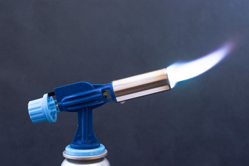 Manual gas burner on a dark background close-up.